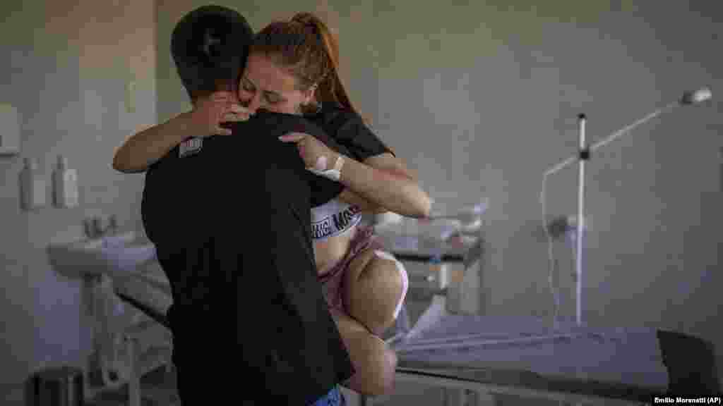 Oksanu Balandinu, 23, nosi njen suprug Viktor u bolnici u Lvivu 13. maja 2022. Oksana je izgubila obe noge i četiri prsta na levoj ruci kada je eksplodirala granata u blizini njene kuće. "Došlo je do eksplozije. Noge su mi se odmah nakon toga osećale kao da padaju u prazninu. Pokušavala sam da pogledam okolo i videla da više nema nogu - samo kosti, meso i krv", priseća se ona. &nbsp;