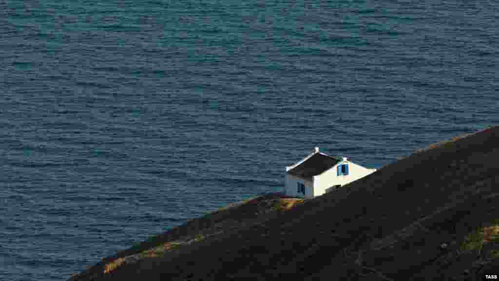 Будиночок внизу &ndash; постійне житло доглядача маяка. Тут ця посада передається у спадок &ndash; від батька до сина. Попередній доглядач Юрій Іванников виріс на маяку. Тут працював його батько. Сам Іванников, пропрацювавши 44 роки, передав цю посаду представникові наступного покоління своєї сім'ї