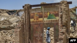 په برمل ولسوالۍ کې یو کس په زلزله کې د خپل ړنګ کور په وره کې ولاړ دی - د جون ۲۳مې انځور. 