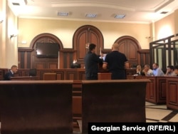 პროკურორი გიორგი მუჯირი გელა დუმბაძეს აჩვენებს რუკებს და სთხოვს მათ შორის არსებული განსხვავებების შესახებ აზრის გამოთქმას მას შემდეგ, რაც დუმბაძემ არაერთხელ თქვა, რომ კარტოგრაფიულ მასალაზე განმარტებებს ვერ გააკეთებდა. მოსამართლემ დაუშვებლად ცნო ეს კითხვა.