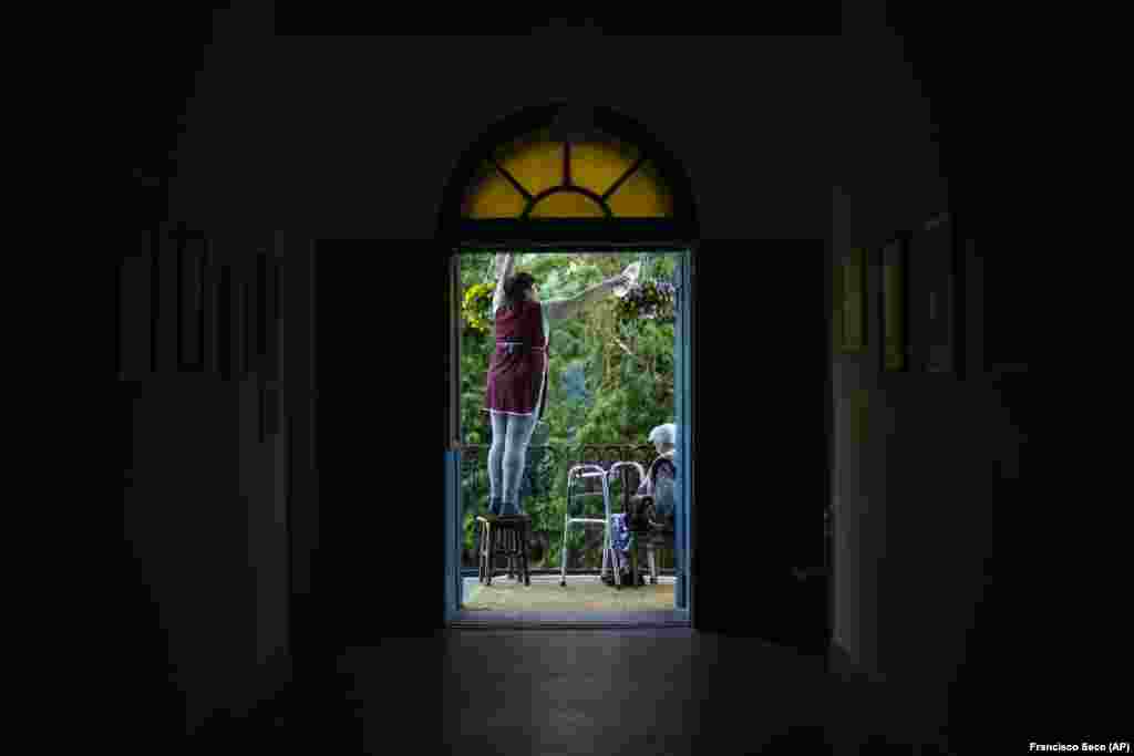 O femeie udă florile la mănăstirea Sf. Mihail din Odesa.