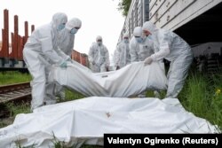 Trupurile soldaților ruși uciși în timpul războiului sunt încărcate de forțele ucrainene într-un vagon frigorific la Kiev. Imagine din 13 mai.REUTERS/Valentyn Ogirenko