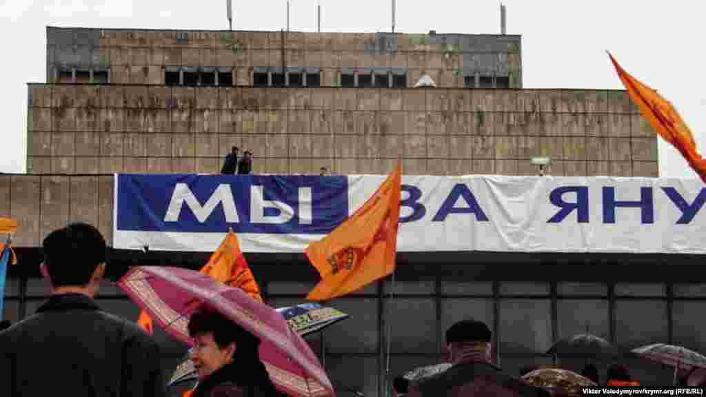 Akimiyet namzetiniñ tarafdarları, Ukrain muzıkalı teatrniñ binasına "Mı za Yanukoviça" ("Biz Yanukoviç içün") yazısını asmağa tırışa, amma şiddetli yel olarğa keder etti.