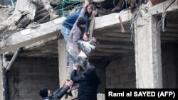  Жители извлекают раненую девочку из-под обломков разрушенного здания после землетрясения в городе Джандарис, в сельской местности города Африн на северо-западе Сирии в удерживаемой повстанцами части провинции Алеппо, 6 февраля 2023 года.