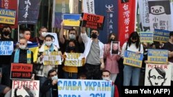 Njerëzit mbajnë pankarta gjatë një proteste kundër pushtimit rus të Ukrainës jashtë zyrës së përfaqësueses ruse në Taipei. 1 mars 2022.