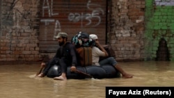 په چارسده کې ځينې رضاکاران خلک خوندي ځای ته رسوي.