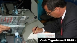 Евгений Жовтис өз кітабына қолтаңбасын қойып отыр. Алматы, 16 сәуір 2012 жыл.