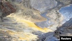 Dy minatorë duke ecur nëpër një minierë të hapur bakri në qytetin serb, Bor, 8 qershor 2013.