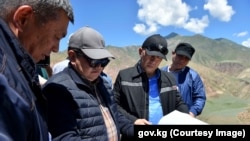 Председатель кабинета министров Акылбек Жапаров (в очках) и министр энергетики Доскул Бекмурзаев (справа) на участке строительства Камбаратинской ГЭС-1. Джалал-Абадская область. 1 июня 2022 года.
