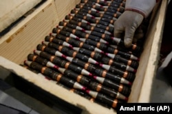 ბოსნიელი მუშა საბრძოლო ტყვიებს ყუთში ათავსებს.