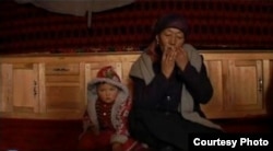 Женщина из тарбагатайских калмак-кыргызов (кыргызов-ламаистов) играет в темир-комузе. СУАР, КНР. Начало XXI в.