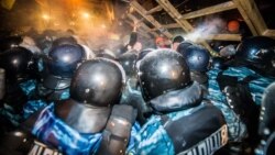 Riot police try to remove a barricade held by protesters on Independence Square in Kyiv early on December 11.