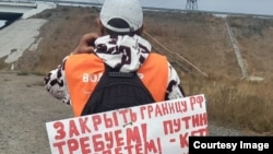 Аскар Нурмаганов с плакатом на спине проводит «велопробег» против прибытия бегущих от мобилизации россиян. Караганда, 26 сентября 2022 года