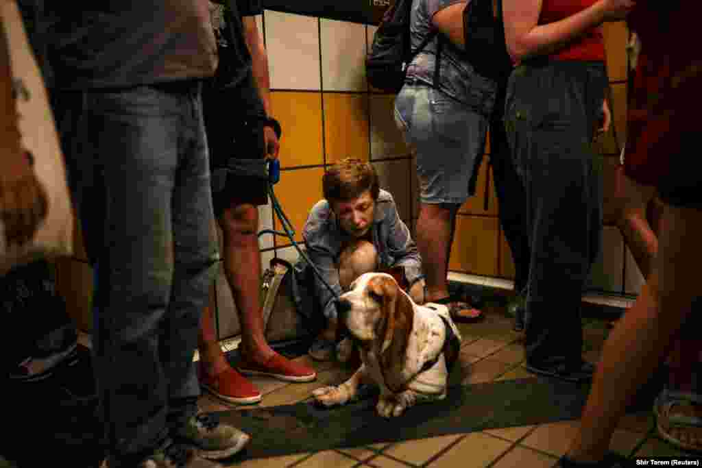 Izraelka sa psom dok se ljudi sklanjaju u tunel žičare nakon raketnog napada Irana na Izrael u Haifi, 17. juna.