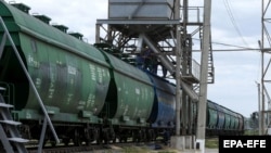 Ілюстрацыйнае фота. Украінскія фэрмэры грузяць зерне ячменю ў вагоны на складах у Адэскай вобласьці, 22 чэрвеня 2022 году