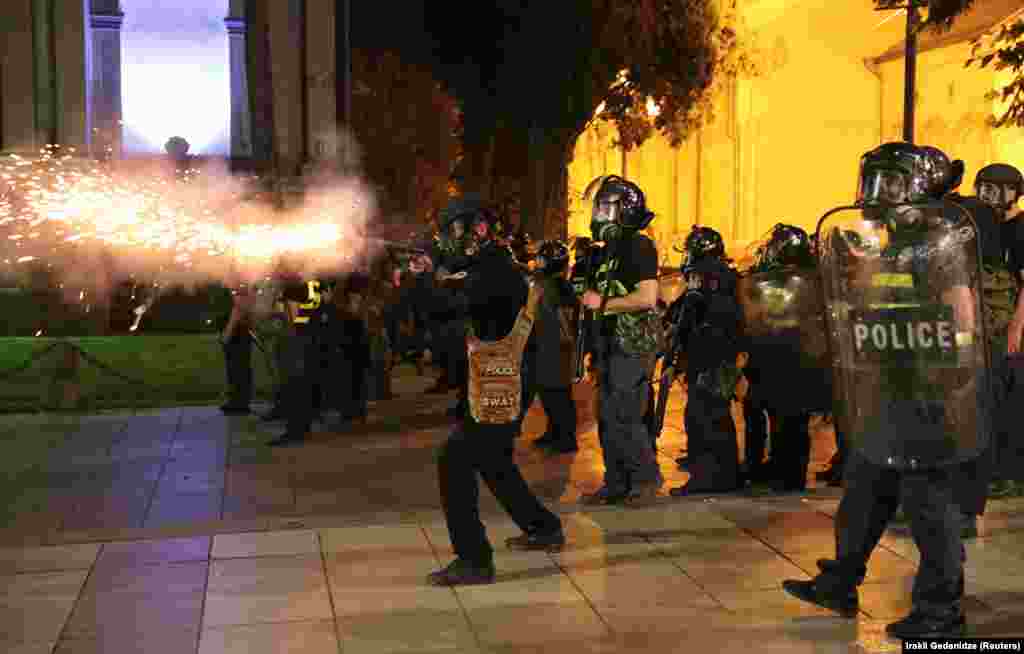 Riot police fire a projectile near the parliament.&nbsp;