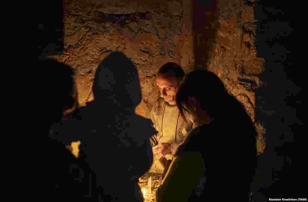 Armenians light candles inside the monastery.