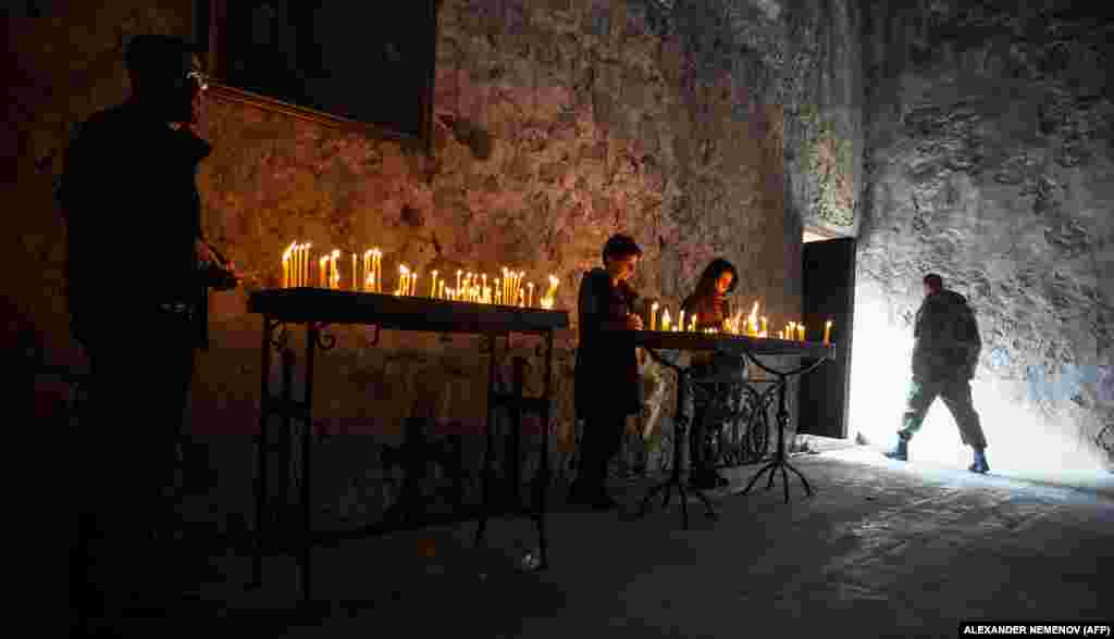Candles burn inside the monastery on November 12 as a mix of soldiers and civilians arrive to pay their respects.&nbsp;