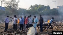 Индия. Нью-Дели. Жакындары коронавирустан өлгөн адамды өрттөөгө даярдап жаткан учуру. 22-апрель, 2021-жыл. 