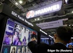 Zaposleni u kompaniji Huavej predstavlja tehnologiju prepoznavanja lica na štandu u Singapuru, 2019. godine.