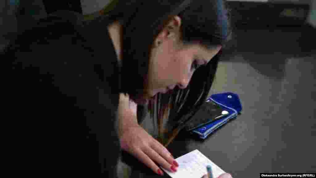 Elmaz Akimova - Han Sarayınıñ "tamiri"ne qarşı&nbsp;bir kişilik piketke çıqqanlardan birisi. Sürette qız rusiye mahkemeleri tarafında apis ve maküm etilgenlerge mektüp yaza.