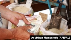 Un bărbat plătește în ruble la o piață din Kazahstan. Valoarea dolarului american a scăzut pe fondul turbulențelor de pe piețele globale de când administrația Trump a prezentat un pachet masiv de tarife vamale, iar rubla rusească a crescut brusc (fotografie de arhivă).