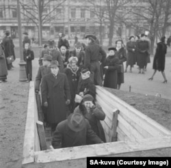 Civilii se retrag într-un adăpost subteran în timpul războiului de iarnă dintre Finlanda și Uniunea Sovietică.