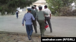 Türkmenistan. Polisiýa saklanan raýaty soraga alyp barýar.