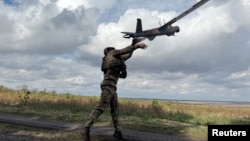Un militar ucrainean lansează o dronă de recunoaștere în apropierea orașului Pokrovsk, situat în zona frontului.