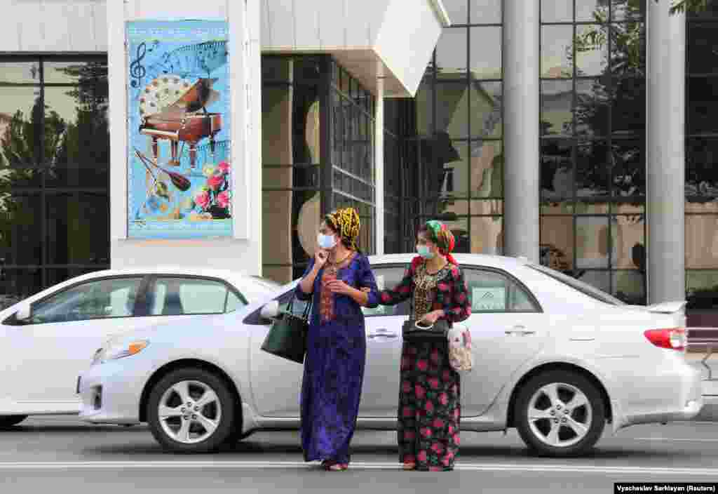 COVID-19-dan goranmak üçin däl, resmi maglumata görä, tozandan goranmak üçin maska geýmeli edilen aýallar köçeden geçýär. Aşgabat, 15-nji iýul.