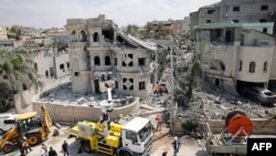 Rescue teams clear rubble in a neighbourhood in the northern Israeli village of Tamra, June 15, 2025.