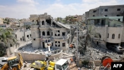 Куткаруу топтору түндүк Израилдеги Тамра айылында үйдүн урандыларын тазалап жатат. 