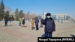 Полицейский с видеокамерой у места предполагаемой акции протеста возле здания акимата. Нур-Султан, 1 апреля 2021 года.