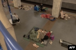 Oameni din Kiev se adăpostesc într-o stație de metrou în timpul atacurilor aeriene rusești, pe 21 august 2025.
