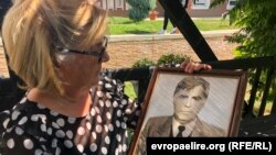 Lutfije Vokshi duke mbajtur në duar fotografinë e vëllaut të saj të zhdukur, Adem Ademi. 