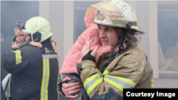 Emergency workers rescue children from a kindergarten in Kharkiv, which was targeted by Russian drones.