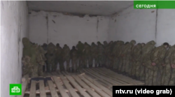 Fotografi e nxjerrë nga reportazhi i marsit 2022 nga rrjeti televiziv rus, i cili është besnik ndaj Kremlinit, NTV, shfaq ushtarët ukrainas që mbahen në kampin e filtrimit në Naroulia, Bjellorusi.