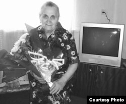 Галина Черемнова - дочь Матрёны Кузнецовой, на фоне телевизора, подарка от акимата. Зыряновск, сентябрь 2005 года. Автор фото - Татьяна Заздравных. Фото было опубликовано в декабре 2005 года в областной газете «Рудный Алтай».