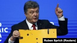 Президент України Петро Порошенко демонструє фрагмент пасажирського автобуса, розстріляного під Волновахою 13 січня 2015 року. Давос, 21 січня 2015 року