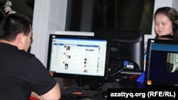 Интернет қарап отырған жігіт пен қыз. Алматы, 2 мамыр 2012 жыл. Көрнекі сурет