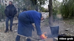Civilians with no access to gas or electricity build a fire in Kostyantynivka.