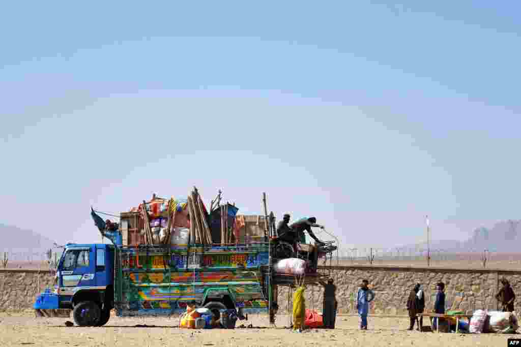 Пакистандан Кандагар провинциясына кайтып келген ооган качкындары өз жүктөрүн түшүрүп жатат.