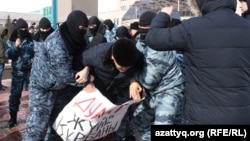 Полицейские Нур-Султана задерживают протестующих. В руках задерживаемого плакат с надписью «Дулат — жертва системы». 1 марта 2020 года.