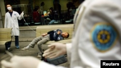 کارکنان صحی چین مردی را که مشکل تنفسی دارد به شفاخانه انتقال می‌دهند.