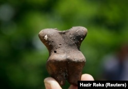 Një aerkelog në Kosovë tregon një pjesë të një ene të qeramikës të gjetur më 2011 në fshatin Reshan, në afërsi të Prishtinës. Ky vendbanim besohet se është i vjetër 6.000 vjet.