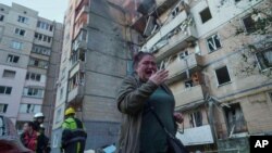 Жінка біля багатоповерхівки, сильно пошкодженою російським ударом у Києві, 7 вересня 2025 року