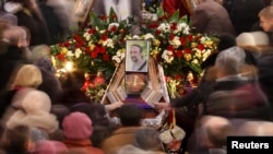 People walk around the coffin of Yuriy Verbytskyy, an antigovernment activist, at his funeral in Lviv on January 24.