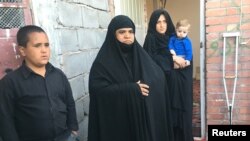 د ایران په کرمان کې د افغانې کورنۍ غړي د خپلې سرپناه مخې ته ولاړ دي ـ پخوانی انځور.