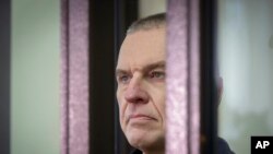 Beloruski aktivista Andžej Počobut stoji u kavezu za optuženike tokom sudskog ročišta u Hrodnu 2023. godine.