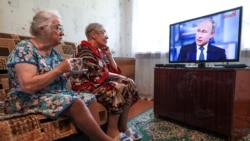 Elderly women watch a live broadcast of Russian President Vladimir Putin's annual question-and-answer session in the village of Yelna, Ivanovo region, on June 7.